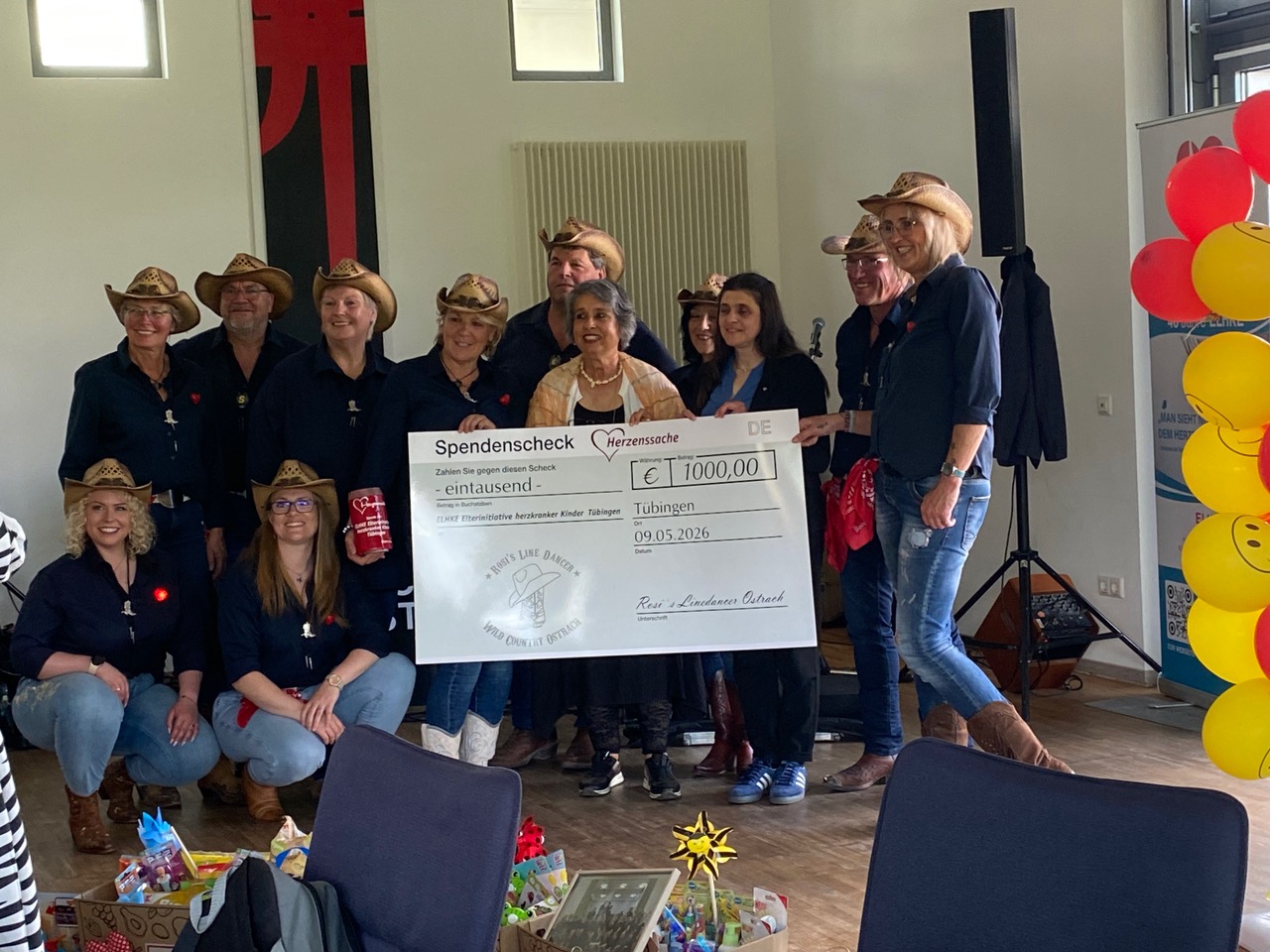 Gruppenbild der Scheckübergabe der Linedancer Ostrach an ELHKE e. V.. In der Mitte stehen Mita Ettischer und Isil Gers und nehmen den Scheck entgegen.
