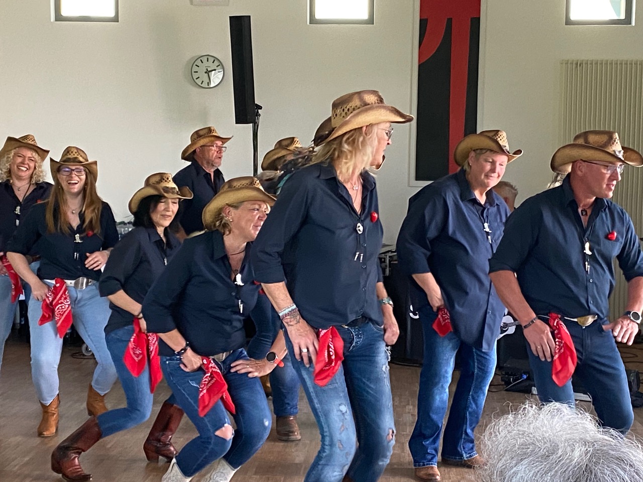 Die Linedancer Ostrach beim Linedance. Männer und Frauen mit Hüten, blauen Hemden und Jeanshosen beim Linedance